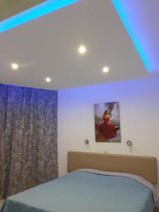 拉纳卡Sunorama Beach Garden 302的一间卧室配有一张床和蓝色的灯光