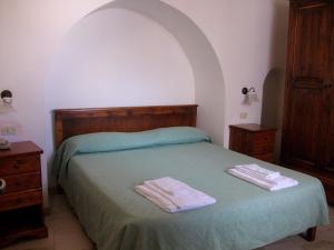 奥斯图尼Masseria Casamassima agriturismo的一间卧室配有一张床,上面有两条毛巾