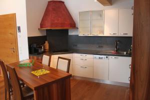 翁肯Haus Bergheim的厨房设有木桌和红色天花板。