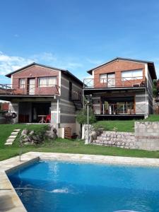 维拉卡洛斯帕兹Cabañas Doña Itati的房屋前有游泳池的房子