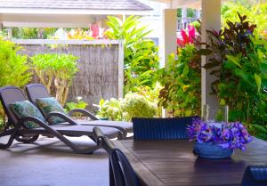 拉罗汤加马卡亚拉巴尔姆斯酒店的庭院里配有一张带椅子和鲜花的木桌