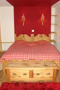 莱迪亚布勒雷珀斯特住所酒店的一间卧室配有一张红墙木床