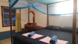 奈岛奈岛海鲜度假酒店的一间卧室配有一张蓝色天蓬床
