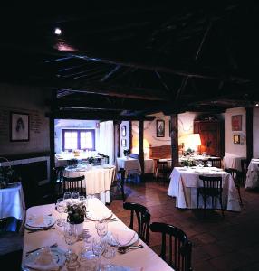 塞哥维亚牧场酒店的用餐室配有桌椅和白色的桌子床单
