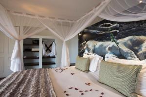 侯斯普瑞特里美拉狩猎山林小屋的一间卧室配有一张大象壁画床