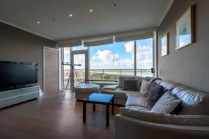 布列登Panoramic & Modern apartment with sea view的带沙发和平面电视的客厅