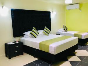 阿皮亚Moatoga Hotel的一间卧室设有两张床和黑色床头板