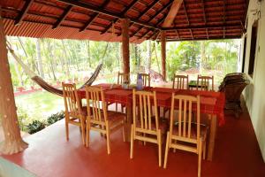 坎努尔海洋绿色喀拉拉邦民宿的一间用餐室,配有红色的桌子和椅子