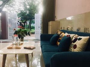 绥和市gau homestay的客厅配有蓝色的沙发和桌子