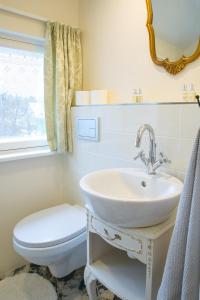 库尔迪加Romance Apartment的一间带水槽、卫生间和镜子的浴室