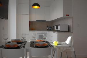 帕苏迪阿尔库什Ocean View double Suite的一间带一张桌子和两把椅子的厨房和一间带白色橱柜的厨房