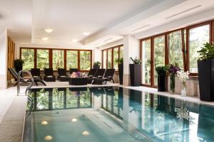 迪马诺卡多林纳FIS亚斯纳酒店的酒店大堂的游泳池,设有椅子和植物