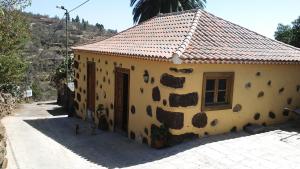 蓬塔戈尔达Casas Rurales Los Marantes的一座黄色的小建筑,设有瓷砖屋顶