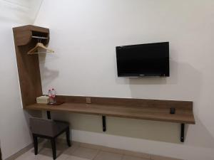 日惹Puri Pangeran Hotel的房间里的墙上有电视
