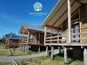 HuillincoCabañas Torre Huillinco的一群木头建筑在田野上