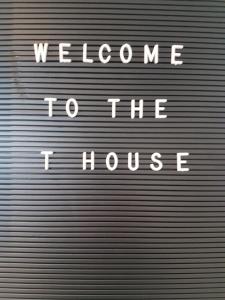 布什米尔斯The T House的金属车库门,上面写着欢迎进房子的话
