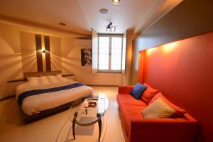 旭川蒂法尼成人酒店的一间卧室配有一张床、一张沙发和一张桌子