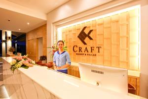 普吉镇CRAFT Resort & Villas, Phuket Town的站在工艺品商店前的妇女