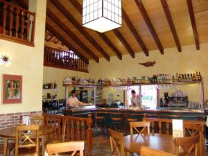 艾因萨Bungalows Peña Montañesa的一间设有酒吧的餐厅,其中两人