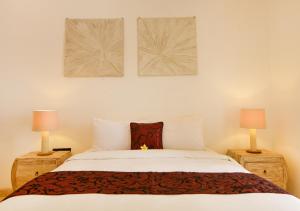 坎古Villa Del Mar Canggu的卧室配有带两盏灯的白色床