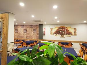 Trobajo del CaminoHostal Restaurante El Abuelo的一间会议室,配有桌椅和植物