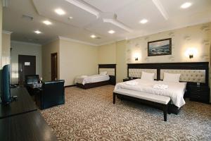 巴库新巴库酒店的一间卧室配有两张床和一台平面电视