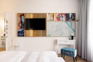 维也纳Hotel Schani Salon的一间酒店客房,配有一张床和一台墙上的电视
