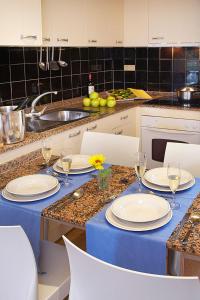 普拉加德阿罗科姆塔特圣霍尔迪公寓式酒店的厨房配有带盘子和酒杯的桌子
