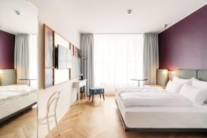 维也纳Hotel Schani Salon的酒店客房配有两张床和一张书桌