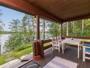 VuoriniemiHoliday Home Illanvirkku by Interhome的木制甲板上配有桌椅