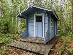 VuoriniemiHoliday Home Kuutti by Interhome的蓝色的外屋,在树林里设有木甲板