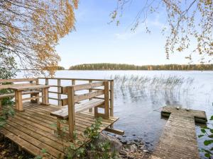 VuoriniemiHoliday Home Aamuntorkku by Interhome的湖上带两个长椅的木甲板