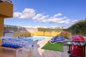 帕尔马海滩伊莎贝尔度假屋的一个带桌椅的庭院和一个游泳池