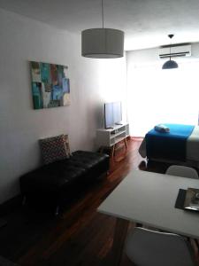 布宜诺斯艾利斯M & C Suites的客厅配有黑色沙发和床。