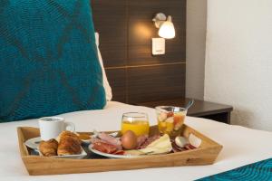 比亚里茨Sure Hotel by Best Western Biarritz Aeroport的床上的早餐食品和饮料托盘