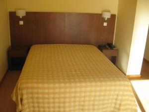 维拉·诺瓦·达·塞尔维尔米尼奥贝罗酒店的卧室内的一张床位,配有黄色和白色的毯子