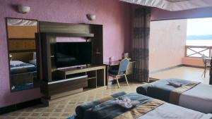 基苏木Milimani Beach Resort的酒店客房设有两张床和一台平面电视。