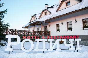 ZhashkivРодичі的雪中的房子,上面标有读酒店和餐厅拱顶的标志