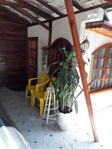 伊瓜苏HAPPY TOUR CHALET的门廊,两把黄色椅子和盆栽