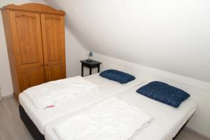 布雷斯肯斯Hello Zeeland - Vakantiehuis Zwin 218的一间卧室设有两张床和木制橱柜
