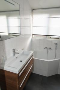 布雷斯肯斯Hello Zeeland - Vakantiehuis Zwin 218的一间带水槽、浴缸和镜子的浴室