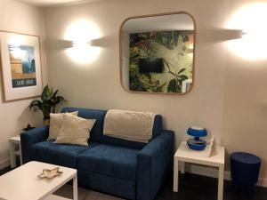 圣马洛Emeraude, pleine vue de mer的客厅配有蓝色的沙发和镜子