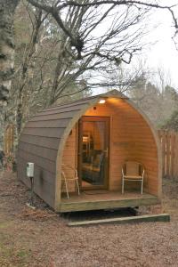 阿维莫尔Pine Marten Bar Glenmore Pods的小屋内设有一个小型的小木屋,配有两把椅子