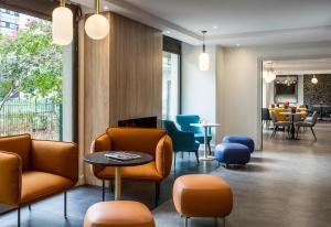 库尔布瓦馨乐庭巴黎德芬斯酒店的一间设有桌椅的等候室和一间用餐室