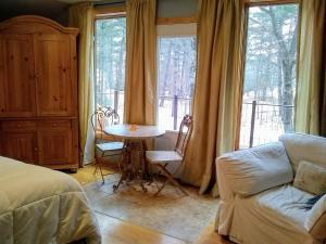 Pine CityBed and breakfast suite at the Wooded Retreat的一间卧室配有桌子、沙发和窗户。