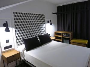 巴利亚多利德Hotel Colón Plaza的卧室配有一张白色大床和一把椅子