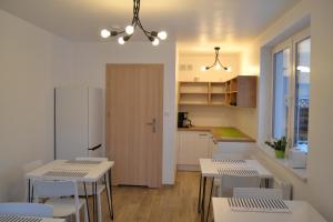 华沙Kalinowy Sen II的厨房配有白色桌椅和冰箱。