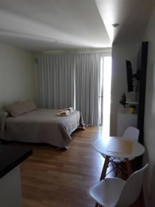 拉普拉塔Excelente Monoambiente Monito 15的一间卧室配有一张床、一张桌子和一个窗户。