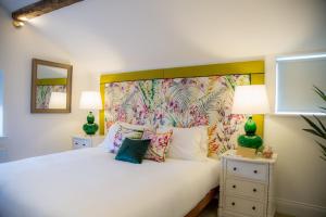 普雷斯顿Winckley Stays的一间卧室配有一张白色的床和色彩缤纷的床头板