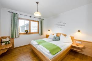 恩斯塔尔豪斯林哈特霍夫农场假期酒店的一间卧室配有一张带绿毯的床